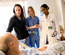 Photo of doctors with a patient. Links to Gifts from Retirement Plans