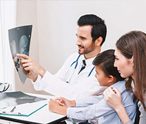 Photo of a doctor showing an xray to a family. Links to Gifts That Protect Your Assets